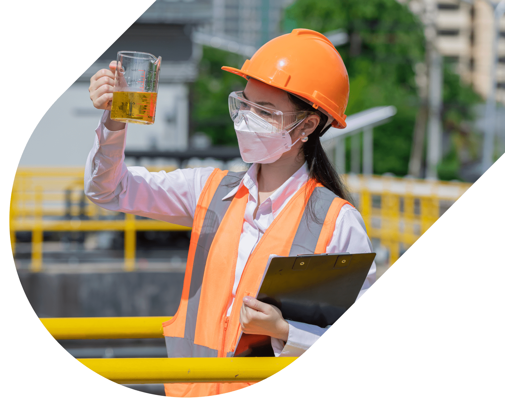Female engineer in safety gear inspecting liquid in a beaker while holding a clipboard at an industrial facility.