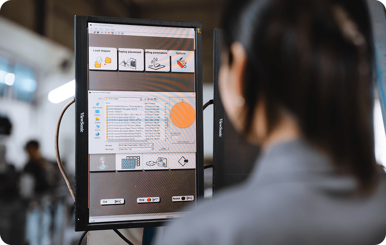 Person operating a CNC machine interface on a ViewSonic monitor, displaying cutting parameters and shape selection.