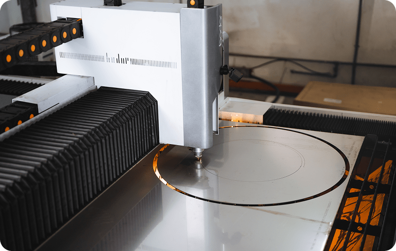 CNC laser cutting machine precisely cutting a circular shape into a metal sheet.