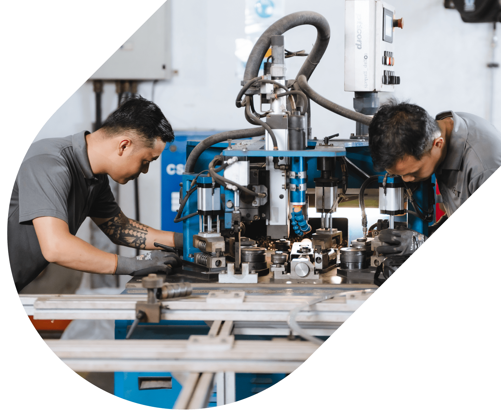 Two technicians operating an industrial CNC machine, focusing on precision part manufacturing.